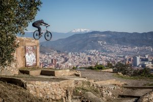 Dominik Raab springt von einer Mauer runter und im Hintergrund sieht man Barcelona und Berge